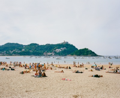 La Concha beach packed with bathers under a soft Basque summer sky