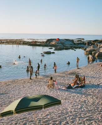 Bathers wading through the tidal pool at Saunders Rocks at golden hour